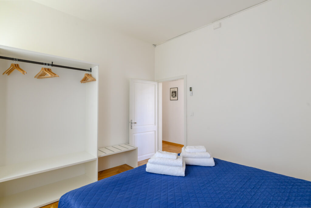 Vista da letto matrimoniale su parete con zona appendiabiti