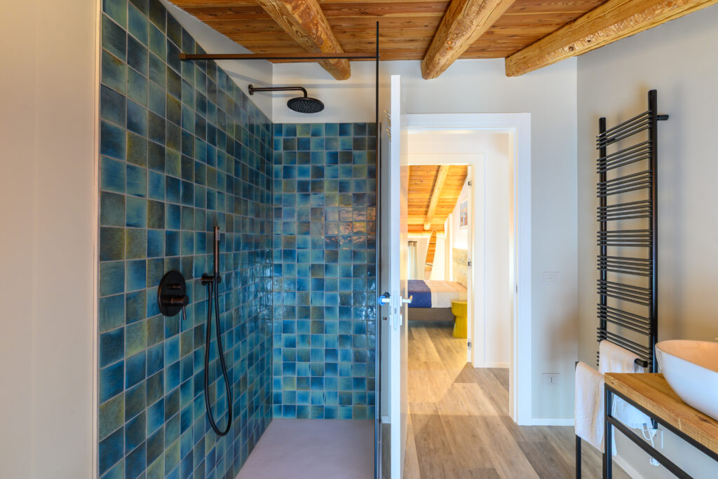 Scorcio di bagno con doccia walk in a piastrelle blu marino