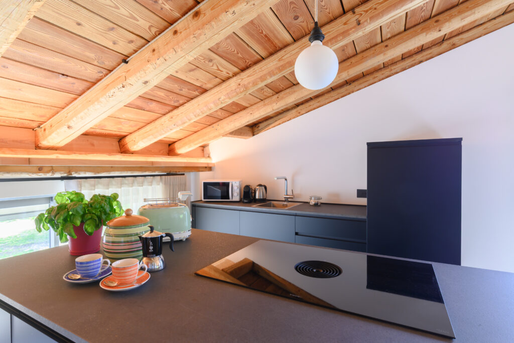 vista su isola moderna color antracite con piano induzione e cappa integrata, e su piano lavello e frigo color antracite