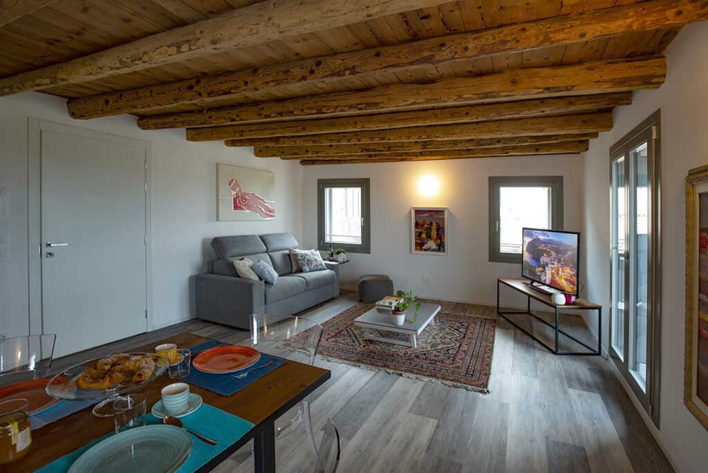 Salotto moderno in ambiente rustico con travatura a soffitto