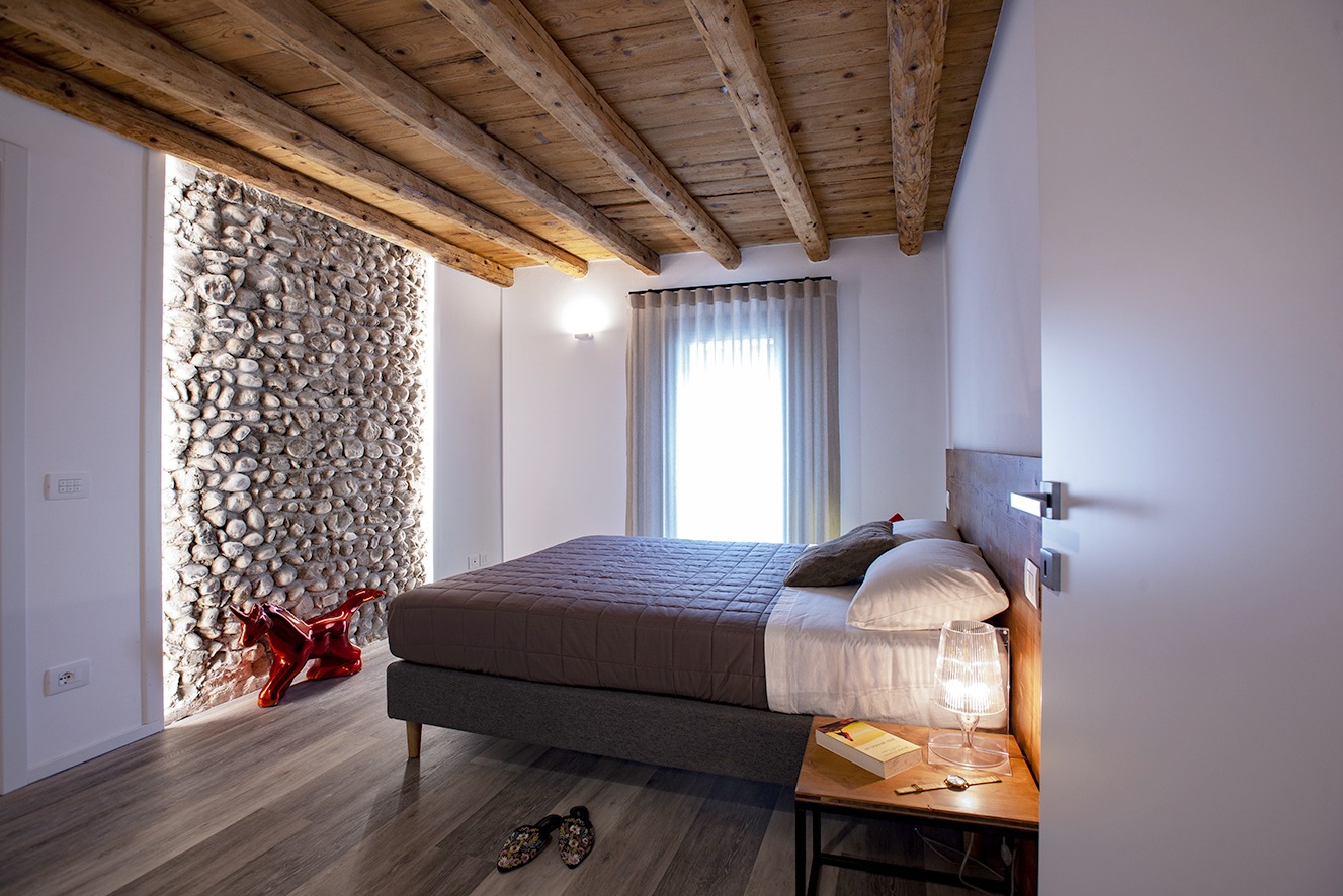camera da letto matrimoniale moderna con soffitto a travatura rustico