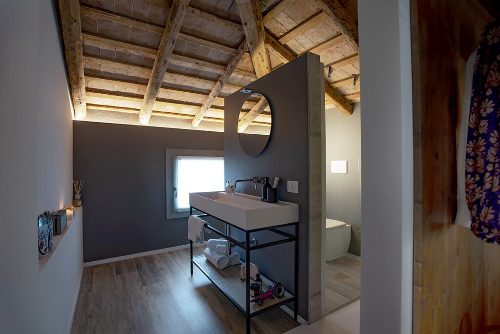 bagno moderno con soffitto a travatura mansardata.