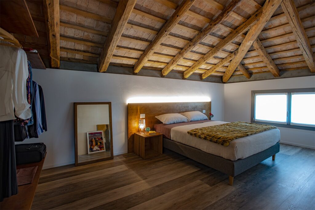 camera matrimoniale con soffitto mansardato a travatura
